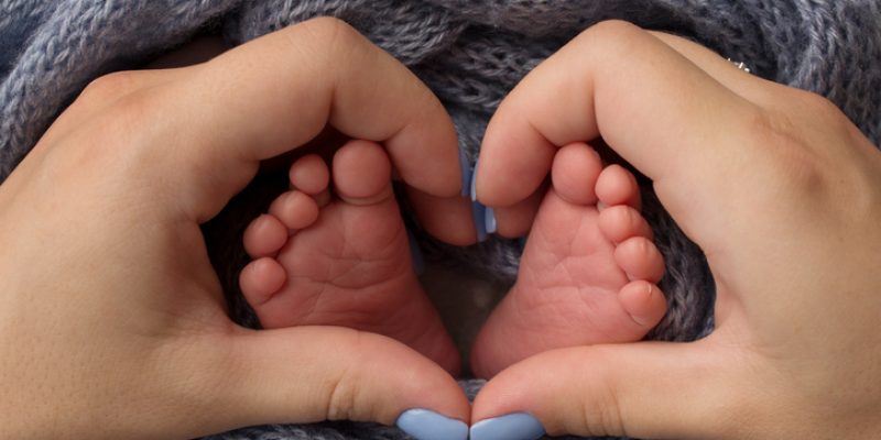 Feet of a newborn close-up in a woolen blanket. Pregnancy, motherhood, preparation and expectation of motherhood, the concept of the birth of a child. High quality photo